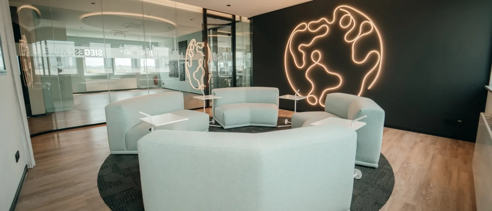 Lounge im Mindbrain-Büro in Holzwickede mit Sitzgruppe und leuchtendem Globus