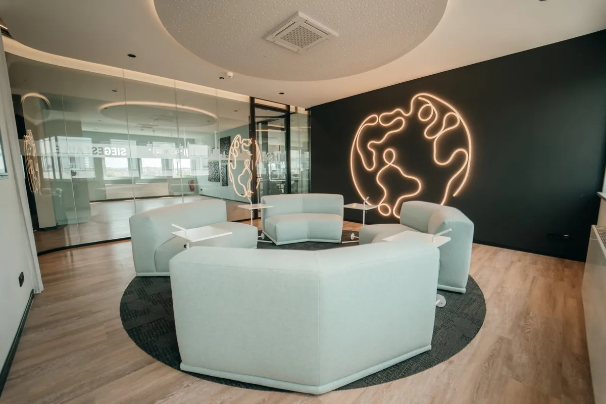 Lounge mit Sitzgruppe und leuchtendem Globus an der Wand